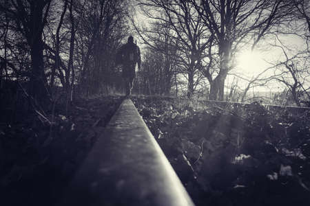 Hiker walking across railroad. B&W imageの写真素材