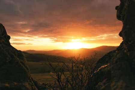 Beautiful sunset with rays over the mountains and rocks at each sideの写真素材