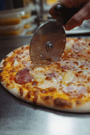 Close-up photo of pizza hawaii cut by cutter wheelの写真素材
