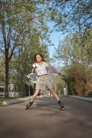 A teenage girl rollerblades in a park on a bright sunny day. Concept is to provide children with...