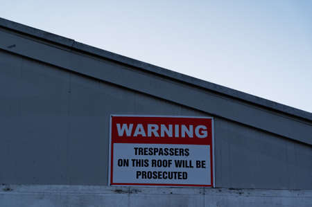 People are warned not to climb on the roof by this sign on a buildingの写真素材