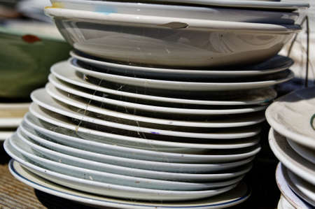 A stack of plates sits gathering cobwebsの写真素材