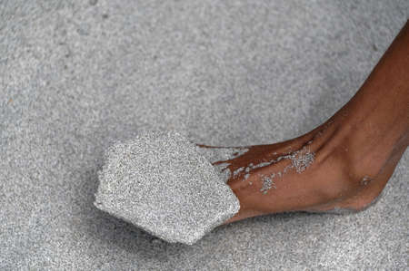 Sand balancing on someone's foot at the beachの写真素材
