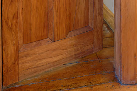A wooden door is open just a crack, making you wonder what is behind itの写真素材