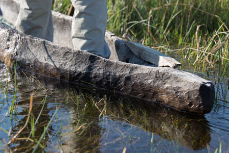 Man standing in mokoro in the Okovango Deltaの写真素材