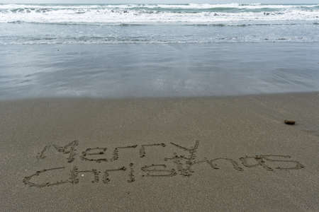 Merry Christmas written in the sand on the beachの写真素材