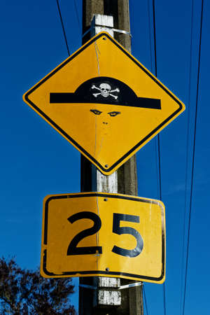 Graffiti changes a yellow and black speed bump warning sign into a pirateの写真素材