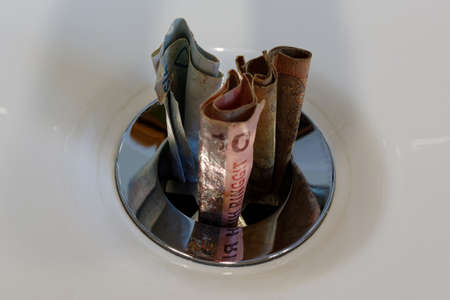 Throwing money down the drain, wastefulの写真素材