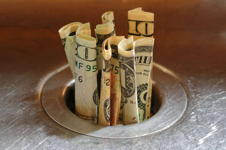 Throwing money down the drainの写真素材