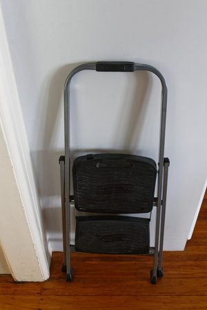 A useful step ladder is leaning against a wall, waiting for the next job