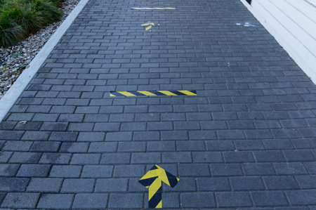 Social distancing lines and arrows are stuck to the pavement outside a shop to remind people about...