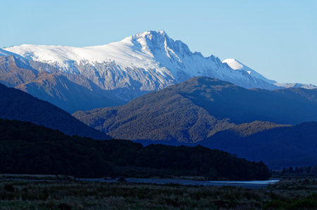 Snow has fallen on the mountain tops, covering them with a white blanketの写真素材