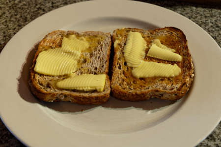 Toast has been generously buttered while it is still warmの写真素材