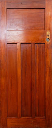 A wooden panel door has had its door handle removed and is waiting to be sanded back before being rehung.の写真素材