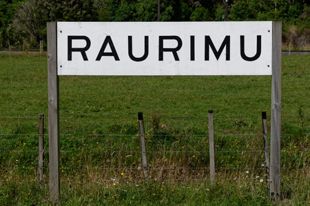 The sign for Raurimu stands on the grass verge. Raurimu is a small settlement in the North Island of New Zealand.の写真素材