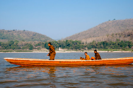 LUANG PRABANG, LAOS - FEBRUARY 16, 2011: Young monks crossing the Mekong River. To this day, this is still the fastest way to cross the river without a motorized vessel.のeditorial素材