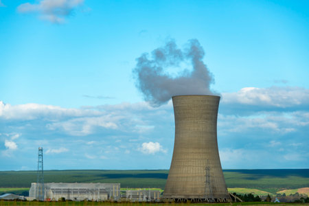 Cooling tower of a nuclear power plant with smoke against the blue skyの写真素材