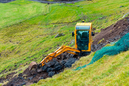 Mini Excavator Clearing a Mountain Passの写真素材