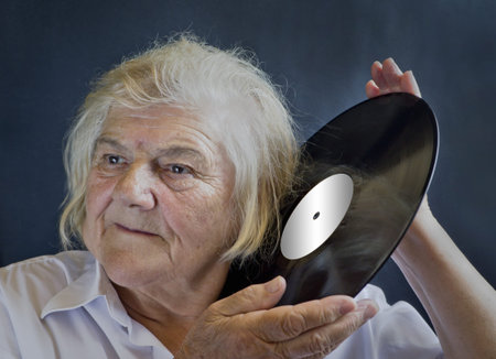 An elderly woman listening LPs. Remembering the past.
