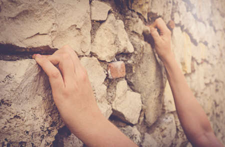 Man climbing on rocky wall, hand detail.の写真素材
