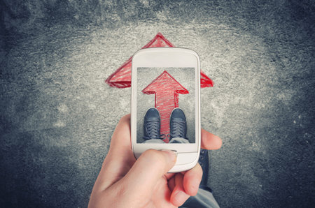 Man photographing his legs on arrow signの写真素材