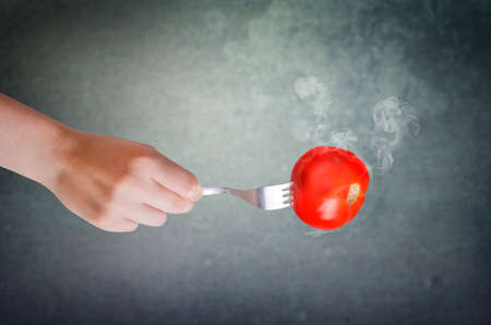 Red tomato on a fork.の写真素材