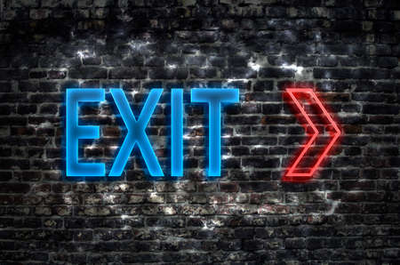 Blue neon exit sign on dark brick wallの写真素材