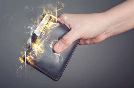 Male hand holding a burning wallet. Fire illustration.の写真素材
