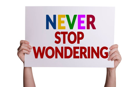 Never stop wondering card in hand isolated on white backgroundの写真素材