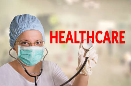 Female doctor touching health care sign with stethoscopeの写真素材