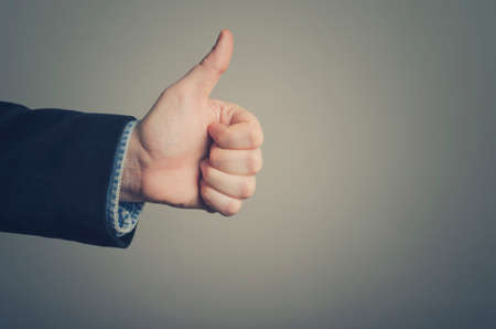 Businessman hand giving thumbs upの写真素材