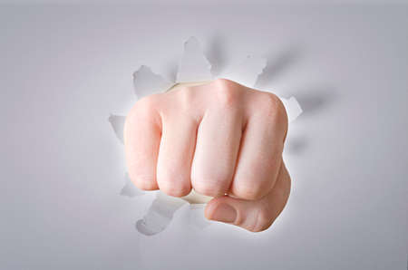Hand break through the white color paper backgroundの写真素材