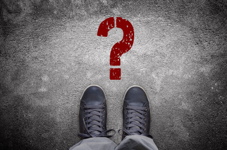 Question mark stencil print on asphalt road with sneakersの写真素材