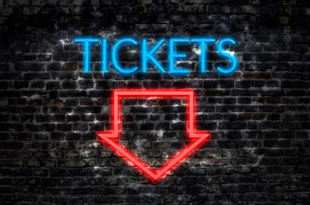 Tickets neon sign on dark brick wall backgroundの写真素材
