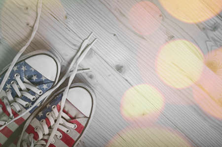 Sneakers with USA flag on wooden background with bokeh lightsの写真素材