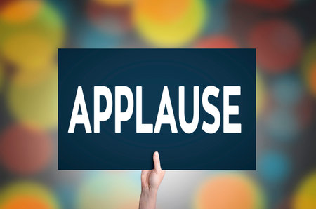 Applause card in hand with bokeh lights background