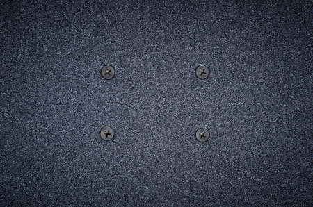 Sandpaper texture background. Black rough sandpaper sheet with screws, close up.の写真素材