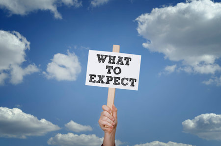 Hand showing board with the message: What to expect
