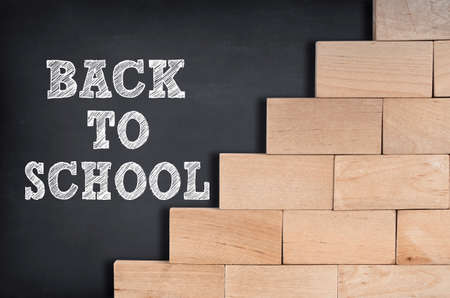 Back to school written on blackboard with wooden blocksの写真素材