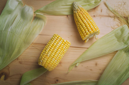 Sweet corns. Fresh corn on cobs on wooden table.