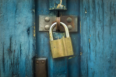 Iron lock on an old blue wooden doorの写真素材