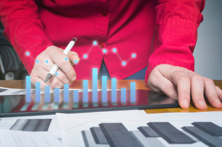 Business person analyzing financial statistics displayed on the tablet screen. Financial planning concept.の写真素材