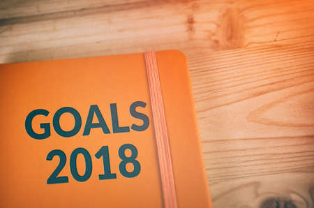 Notebook with New Year`s goals for 2018 on wooden table backgroundの写真素材