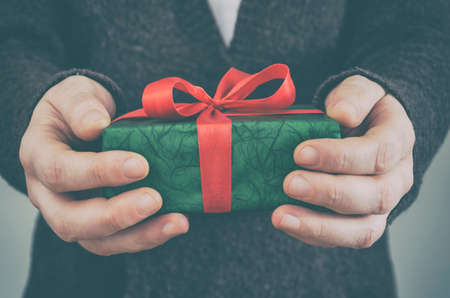 Close up of man hands holding gift boxの写真素材