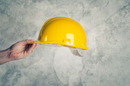 Yellow construction helmet in hand.の写真素材