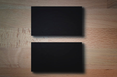 Closeup mockup of two blank horizontal business cards at natural wooden background