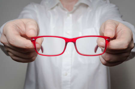Eye care concept. Doctor ophthalmologist giving new glasses to patient, close up.の写真素材