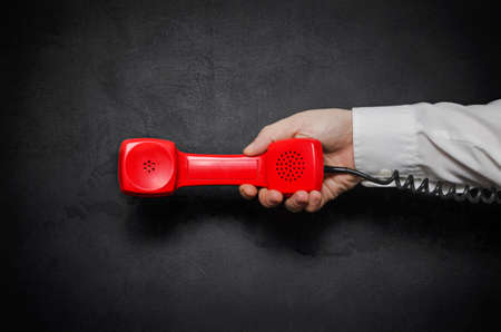 Hand with red old fashioned style telephone handset receiverの写真素材