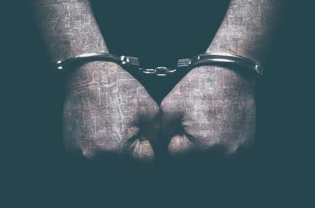 Male hands with handcuffs patterned with no-sense words. Concept of censorship and freedom of the press.の写真素材