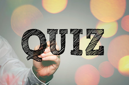 Businessman`s hand writing Quiz text with felt tip pen on transparent wipe board
